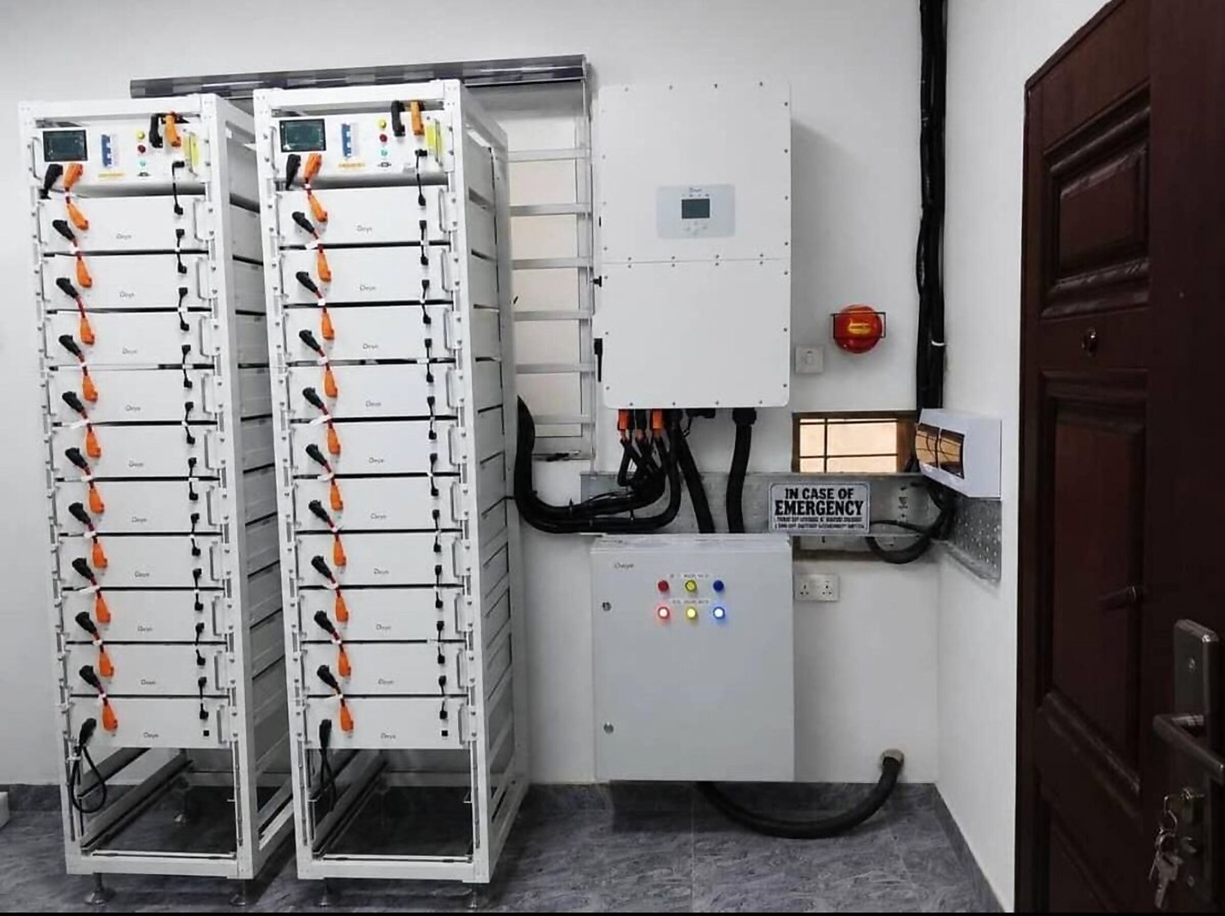 Two tall lithium battery racks with an inverter and changeover panel